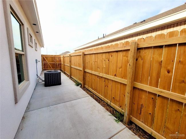 Fenced backyard featuring cooling unit and a patio area | Image 4