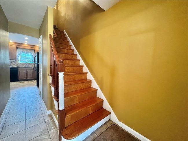 View to kitchen from tiled front hallway. Stairway to upstairs | Image 10