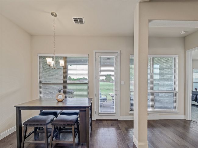 Dining room with a chandelier and dark wood-style floors | Image 13