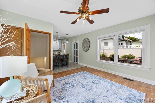 Living room featuring light wood-style flooring and a ceiling fan | Image 15