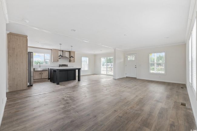 Unfurnished living room featuring wood finished floors and ornamental molding | Image 9