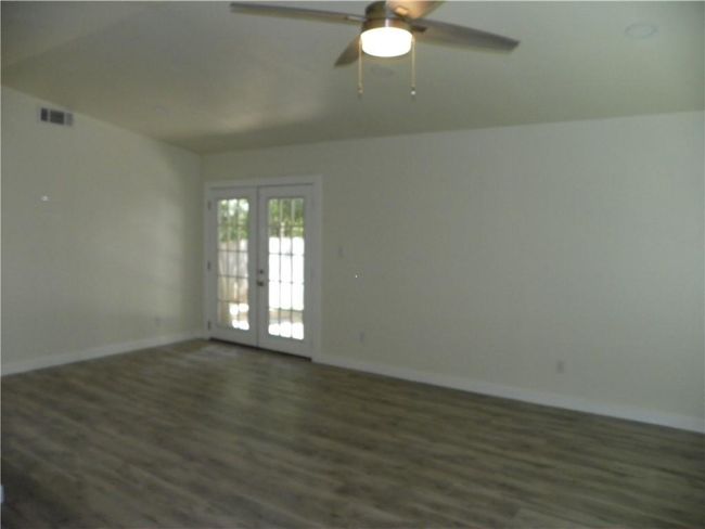 Spare room featuring french doors, wood finished floors, and a ceiling fan | Image 7