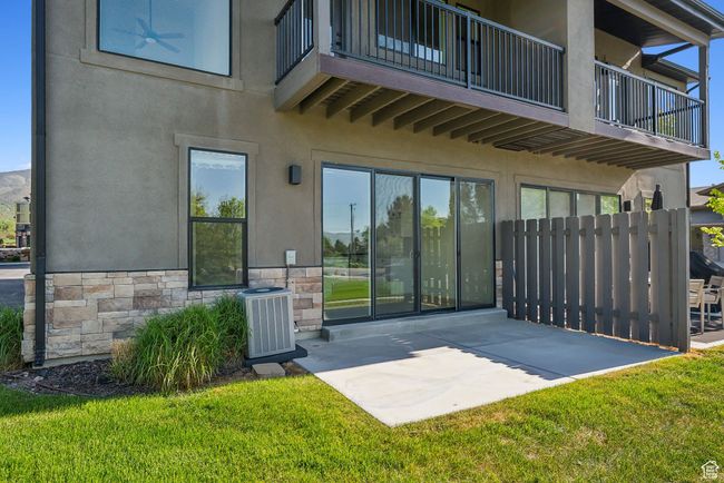 Back of property with a balcony, a patio area, and stucco siding | Image 43