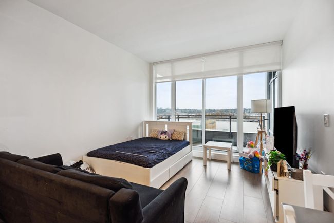 Bedroom featuring floor to ceiling windows and wood finished floors | Image 11