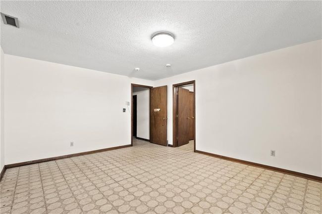 Spare room featuring baseboards, light floors, and a textured ceiling | Image 23