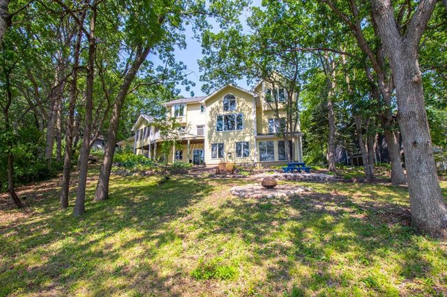 Another view of the backyard in the summer. Notice there is an area for a firepit and a bit closer to the house there is a gravel landing which is a great place for a picnic table or some comfy chairs to relax and enjoy the view. | Image 42