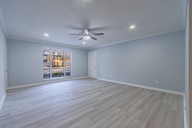 Spare room featuring crown molding, light hardwood / wood-style flooring, and ceiling fan | Image 32