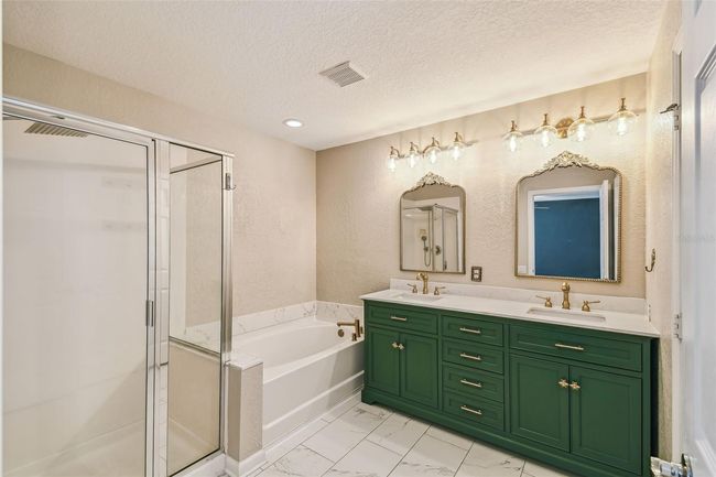 Upstairs primary bedroom features an en-suite, updated bathroom complete with a double vanity, garden tub, walk-in shower, and a private toilet closet. | Image 16