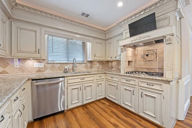 Gas stove with water filler, stainless appliances, and a TV all ready for you to start creating meals here. | Image 10