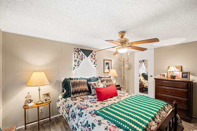 Bedroom with a textured ceiling, wood finished floors, and ceiling fan | Image 10