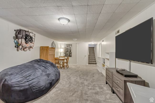 Interior space with visible vents, carpet flooring, and stairs | Image 17