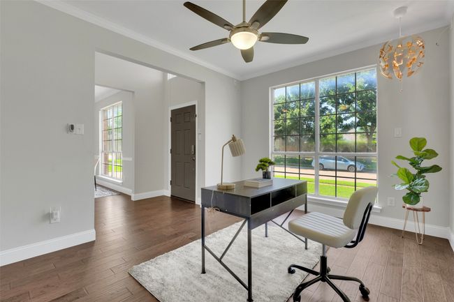 Office area featuring ornamental molding, dark wood-style floors, a ceiling fan, and a chandelier | Image 6