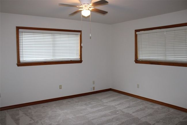 Second bedroom featuring ceiling fan, light carpet, and natural baseboards | Image 19