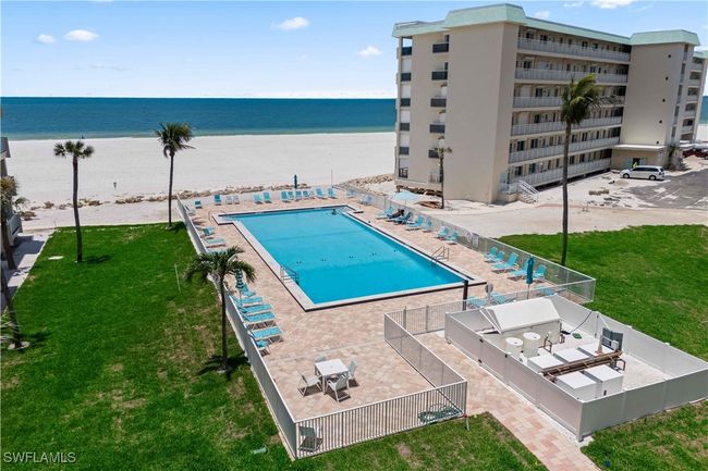 The community pool offers a refreshing retreat just steps from the sandy beach, with stunning Gulf views creating a serene and relaxing atmosphere. | Image 28