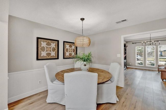 Dining space featuring a textured ceiling, visible vents, an inviting chandelier, and light wood finished floors | Image 12