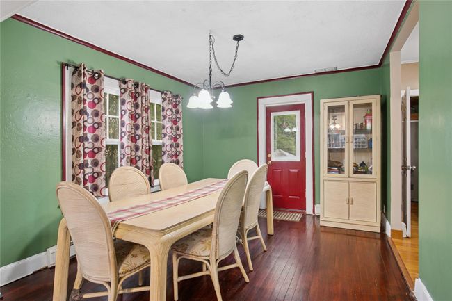 Dining room featuring baseboards, an inviting chandelier, crown molding, visible vents, and hardwood / wood-style flooring | Image 12