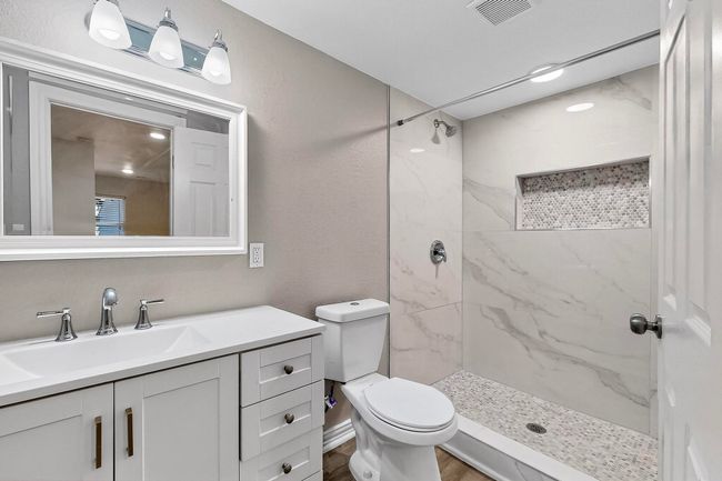 Full bathroom featuring vanity and a marble finish shower | Image 13