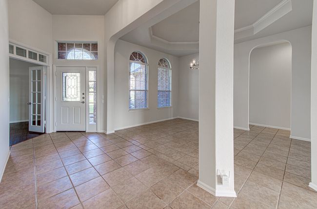 Foyer featuring a raised ceiling, light tile patterned floors, and baseboards | Image 5