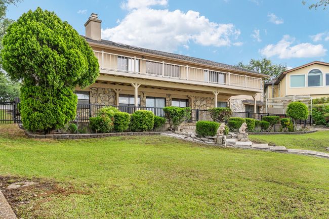 Rear view of property with a yard, stone siding, a chimney, and fence | Image 35