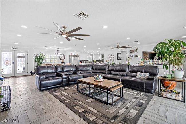 Living room featuring french doors, a ceiling fan, visible vents, ornamental molding, and recessed lighting | Image 9