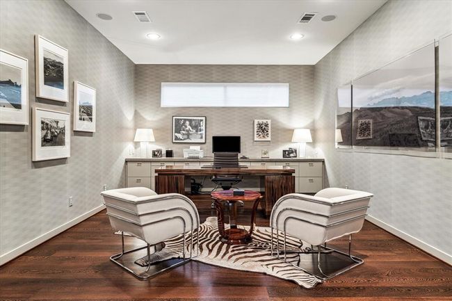 Second Floor STUDY (19 X 14) with its wide plank hardwood flooring, built-in desk with stone countertop and filing cabinets below, built in book-shelving, papered walls, base molding, raised horizontal privacy window with shade, ceiling speakers, pocket doors entry, painted walls, recessed lighting. | Image 27