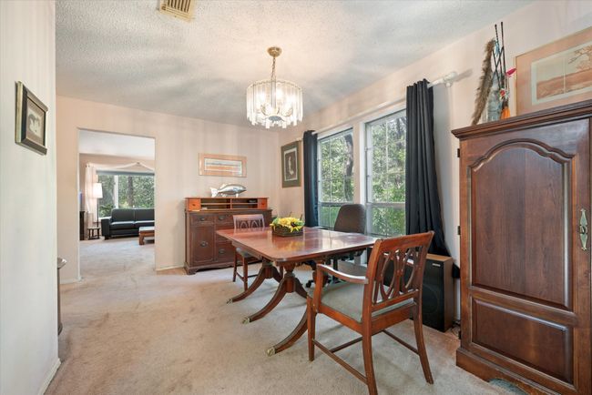 Carpeted dining area with a wealth of natural light, a chandelier, and a textured ceiling | Image 17
