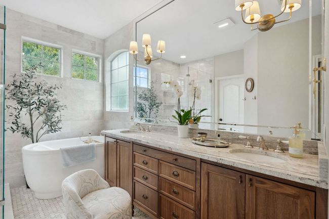 Enjoy your own private deluxe primary ensuite bathroom, beautifully updated with a custom maple vanity and Rohl fixtures. | Image 23