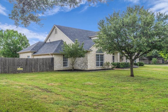 View of side of home featuring stone siding and roof with shingles | Image 5