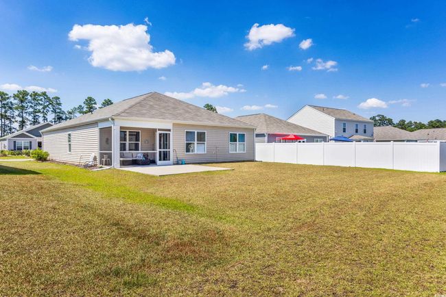 Rear view of house featuring a patio, a sunroom, and roof with shingles | Image 33