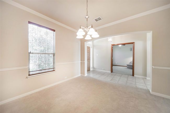 Spare room with light colored carpet, a chandelier, light tile patterned flooring, and ornamental molding | Image 4