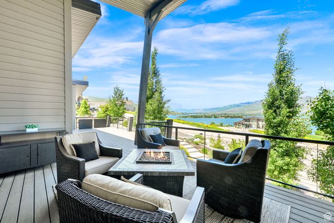 Deck featuring a water and mountain view and an outdoor living space with a fire pit | Image 78