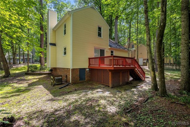 Rear view of house featuring stairs, a deck, and wooded backyard | Image 28