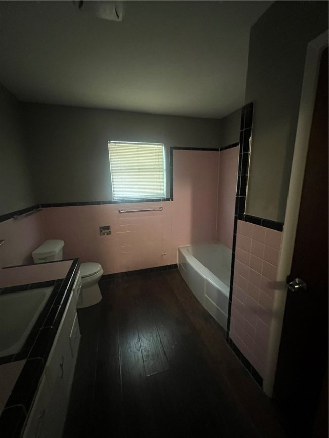 Bathroom with tile walls, hardwood / wood-style flooring, vanity, toilet, and wainscoting | Image 10