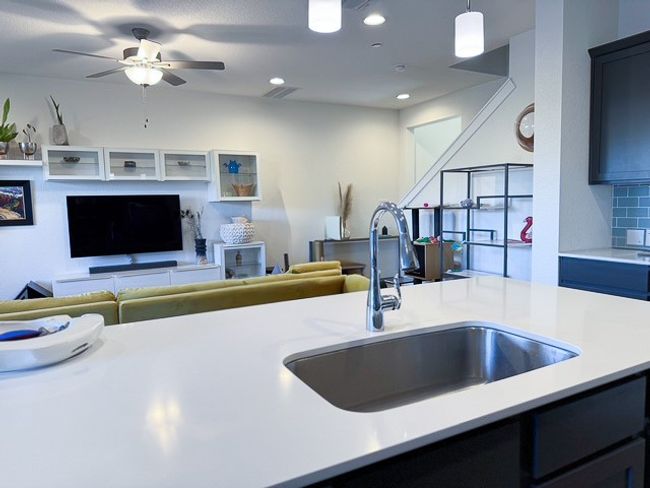 Kitchen featuring open floor plan, light countertops, a sink, and backsplash | Image 6