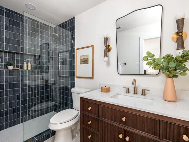 Bathroom featuring toilet, tiled shower, and vanity | Image 7