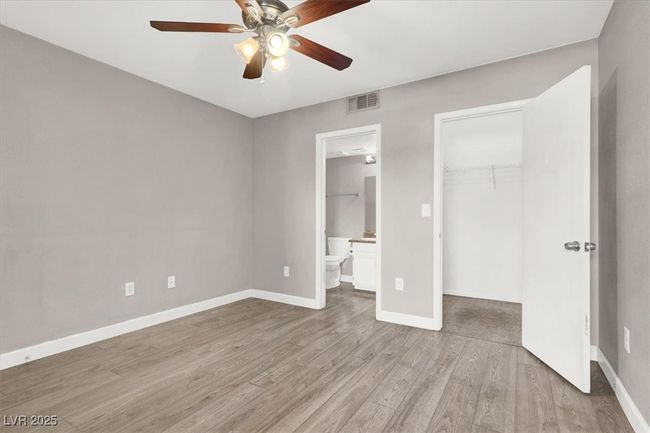 Unfurnished bedroom featuring baseboards, visible vents, wood finished floors, a closet, and a walk in closet | Image 15