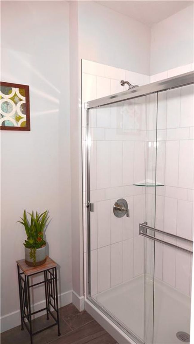 Full bath featuring baseboards, tiled shower, and wood finished floors | Image 40