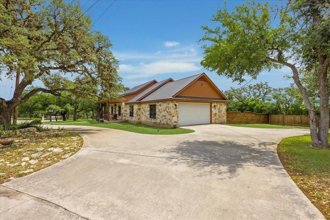 The side entrance to the garage is on the right side of the home and there is a circle driveway. | Image 4