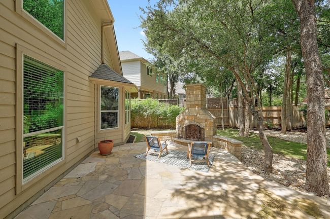 The outdoor stone fireplace is the perfect centerpiece for the patio, offering warmth and ambiance, making it an ideal spot for cozy gatherings or relaxing nights under the stars | Image 6
