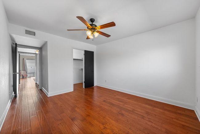 Bedroom with ceiling fan, wood-style flooring and spacious closet | Image 22