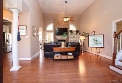 featuring ceiling fan, ornate columns, a fireplace, and wood flooring | Image 2