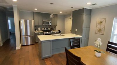 Kitchen featuring gray cabinetry, stainless steel appliances, sink, and dark wood-type flooring | Image 3