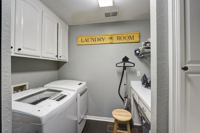 Laundry room featuring visible vents, baseboards, washer and dryer, cabinet space, and tile patterned flooring | Image 18