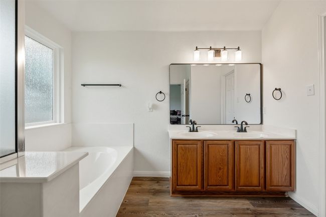 Bathroom with healthy amount of natural light, wood finished floors, and double vanity | Image 27