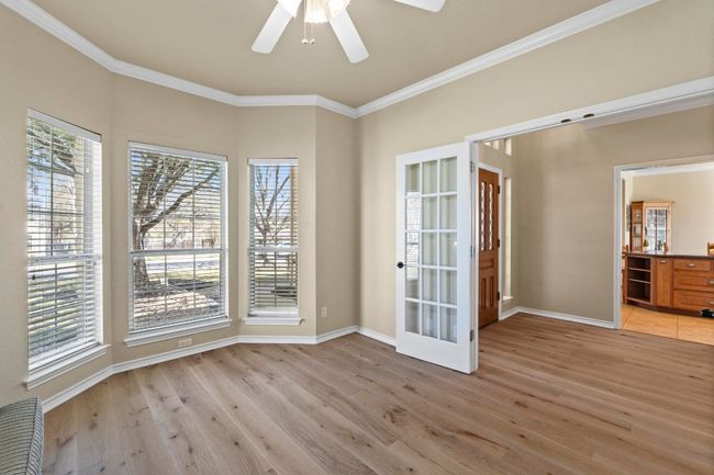 Empty room featuring light wood-style flooring, baseboards, crown molding, and a ceiling fan | Image 19