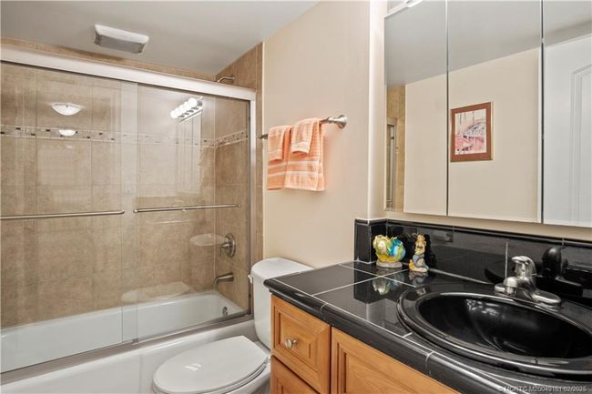 Tub shower in guest bathroom with granite countertops | Image 23