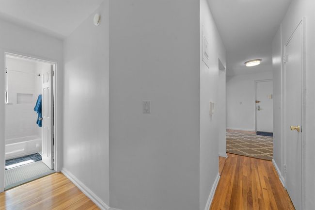 Hallway with baseboards and wood finished floors | Image 24