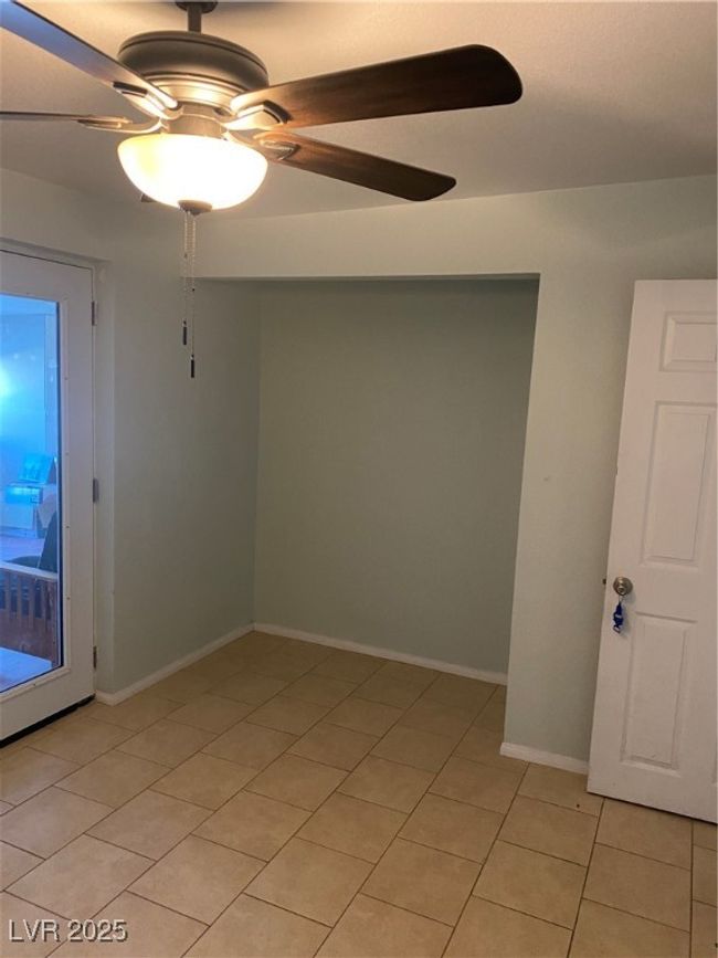 Unfurnished room with baseboards, light tile patterned floors, and a ceiling fan | Image 13