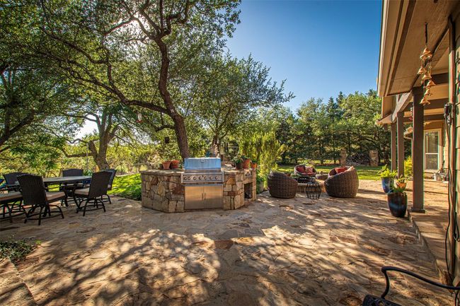 View of patio / terrace featuring area for grilling, outdoor dining space, and view of scattered trees | Image 28