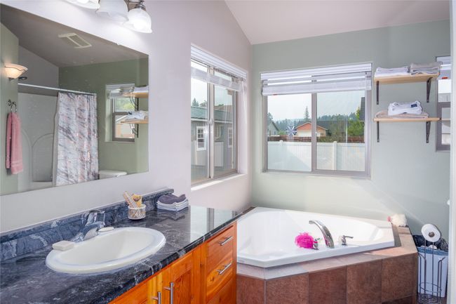 Full bathroom with a bath, vanity, vaulted ceiling, and plenty of natural light | Image 45
